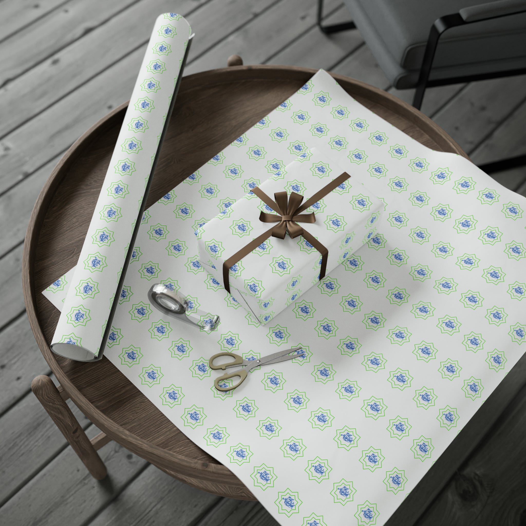 Gift-wrapping materials with Eid Celebration Wrapping Paper - Ramadan Inspired Design for Meaningful Gifts by Medina Roots on a wooden table for Ramadan.