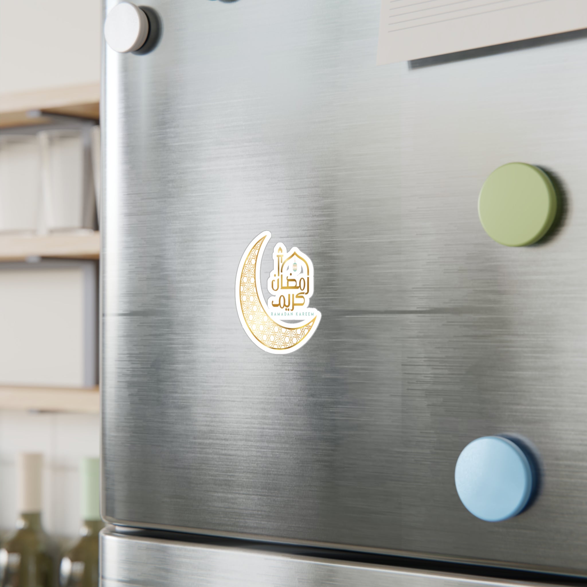 Stainless steel refrigerator door with a "Ramadan Kareem" Medina Roots sticker and Arabic calligraphy magnet, flanked by colorful circular magnets.