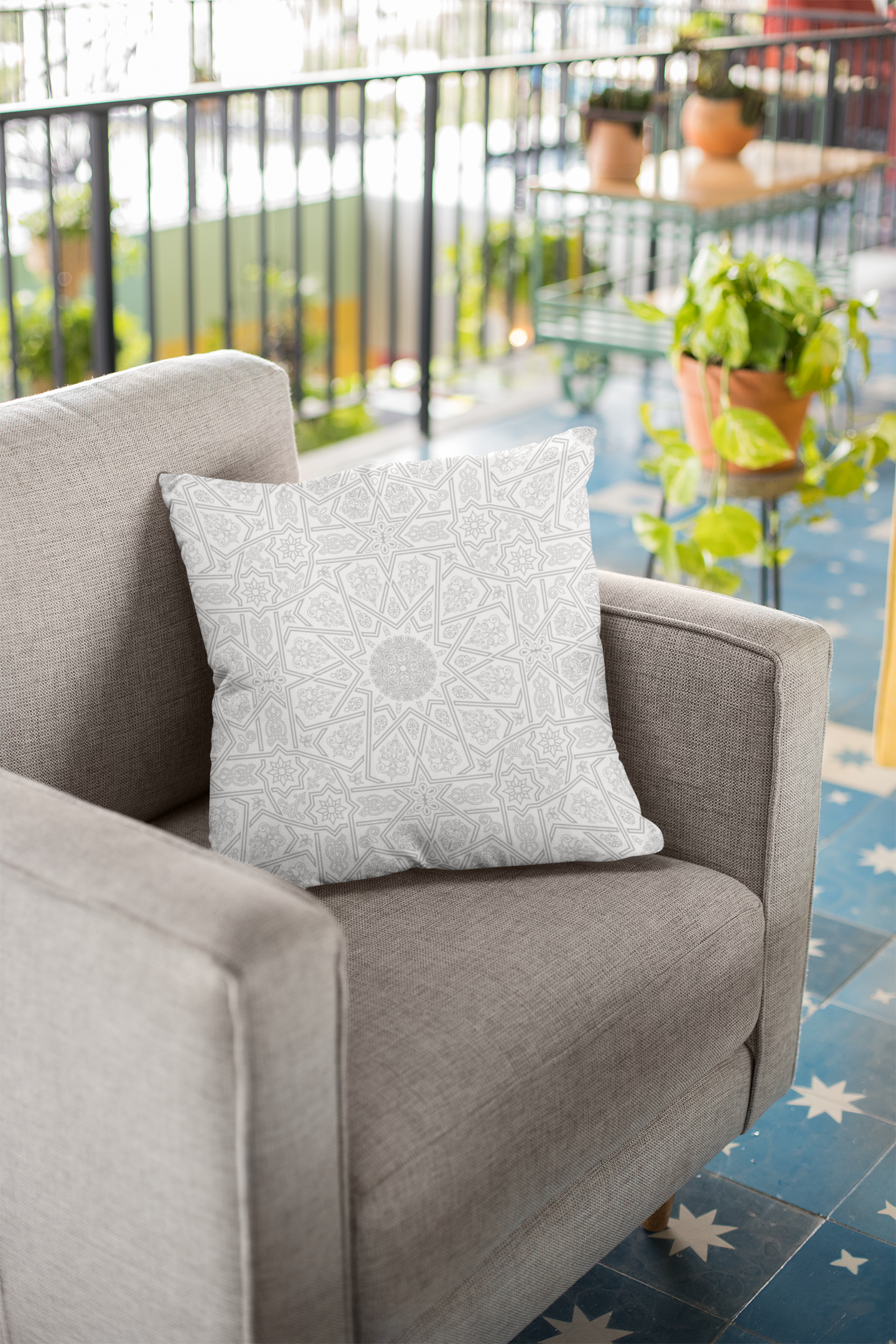 Medina Roots Geometric Patterned Throw Pillow Cover on a gray armchair on a balcony with potted plants.