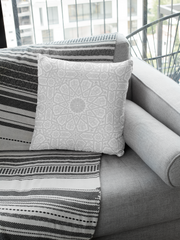 Medina Roots' decorative Geometric Patterned Throw Pillow Cover on a modern grey sofa with a striped throw blanket.