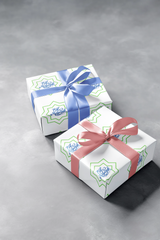 Two wrapped Eid Celebration Wrapping Paper gift boxes with blue and pink ribbons on a gray background for Ramadan by Medina Roots.